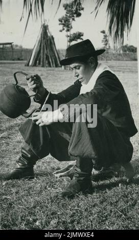 Altes Schwarz-Weiß-Foto eines jungen Südamerikaners Gaucho, der aus einem Kessel Verba-Maté ausgießt, ca. 1950 Stockfoto