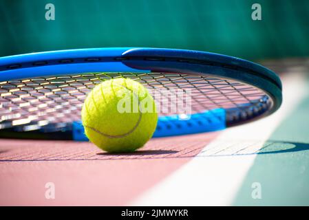 Tennisschläger und Ball liegen auf dem Platz. Gesundes Lifestyle-Konzept Stockfoto