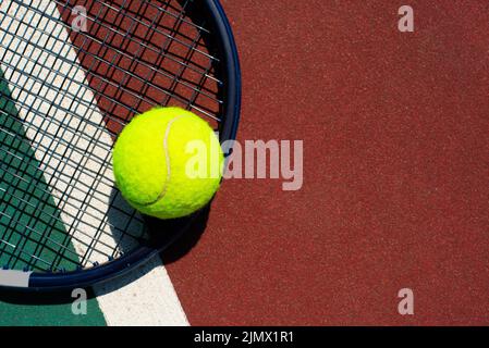 Tennisschläger und Ball liegen auf dem Platz. Platz für Text Stockfoto