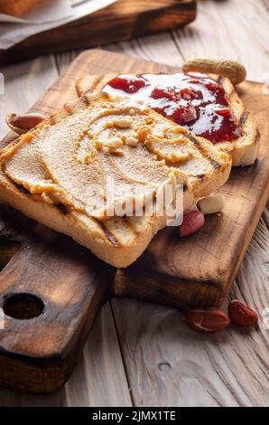 Nahaufnahme aus der Nähe von Erdnussbutter und Marmelade-Sandwiches auf Schneidebrett. Gesunde Ernährung Konzept Stockfoto