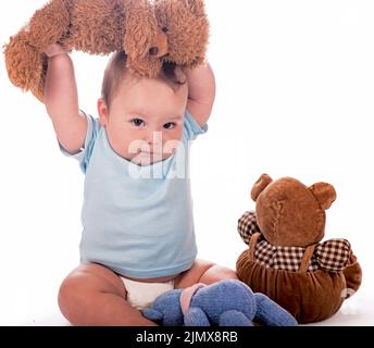 Baby mit Teddybären. Süßes Kind mit Teddybären isoliert auf Weiß Stockfoto