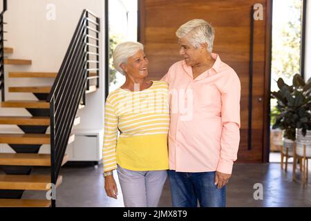 Lächelnde, ältere Freunde aus der Birazialzeit schauten einander an, während sie im Pflegeheim gegen die Tür standen Stockfoto