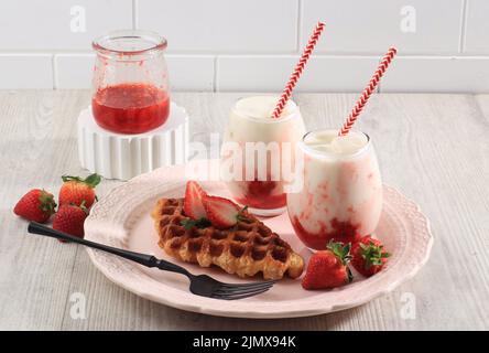Rosafarbene Waffel aus Crossant oder Crossant. Craffle ist ein viraler Kuchen aus Südkorea. Serviert mit koreanischer Erdbeermilch. Speicherplatz Kopieren Stockfoto