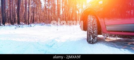 Low-Angle-Ansicht am Autorad auf verschneite Straße im Wald Stockfoto