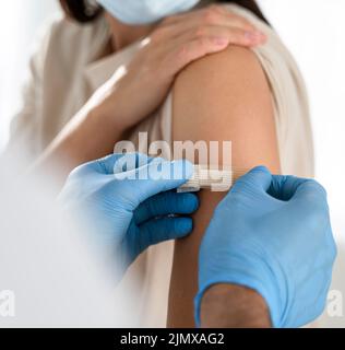Arzt legt den Arm des Patienten mit Verbänden aus nächster Nähe an Stockfoto
