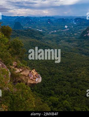 Dragon Crest Berg Krabi Thailand, ein junger Reisender sitzt auf einem Felsen, der den Abgrund überhängt, mit einer wunderschönen Landschaft. Ziehen Stockfoto