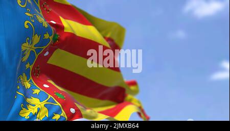 Die Flagge der Valencianischen Gemeinschaft winkt an einem klaren Tag im Wind Stockfoto