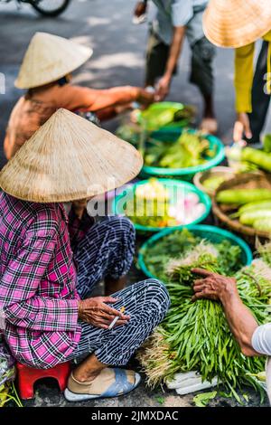 Frauen verkaufen Lebensmittel auf der Straße von Hoi an in der Provinz Quang Nam Stockfoto