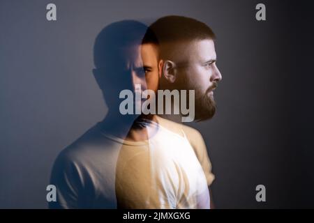 Doppelbelichtung crative Seitenansicht Profil und Porträt von künstlerischen bärtigen Modell Mann in weißem T-Shirt Blick auf die Kamera mit ruhigen ernsten Gesicht. Spezielle verwischte Beauty-Effekt. Innenaufnahme Studio. Stockfoto