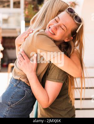 Junge Frauen umarmen sich gegenseitig Stockfoto