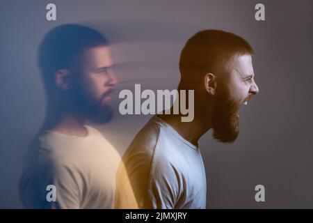 Seitenansicht Porträt eines zweigesichtigen Mannes in einem ruhigen, ernsten und wütenden Schreien. Unterschiedliche Emotionen innerhalb und außerhalb der Stimmung. Innerlich leidend, dissoziative Identitätsstörung. Doppelbelichtung. Stockfoto