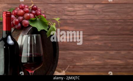 Holzfass mit Flasche Glaswein Stockfoto