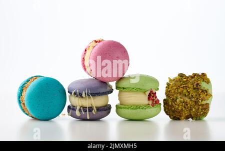 Runde französische Kuchen aus Mandelmehl-Makronen auf weißem Hintergrund. Aroma von Himbeere, Pistazie und Lavendel Stockfoto