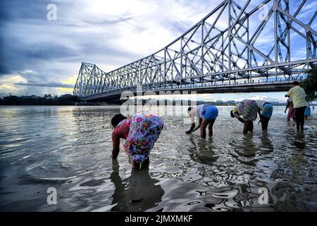 Kalkutta, Indien. 07. August 2022. Die Einheimischen sahen, wie sie sich im Fluss Ganges unter der Howrah-Brücke Hände und Kleidung wuschen. (Foto: Avishek das/SOPA Images/Sipa USA) Quelle: SIPA USA/Alamy Live News Stockfoto