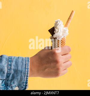Frisches Eis mit Hand aus Schokoladenkonus Stockfoto