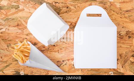 Französisch frites Papier Konus weiß Paket hölzernen Hintergrund Stockfoto