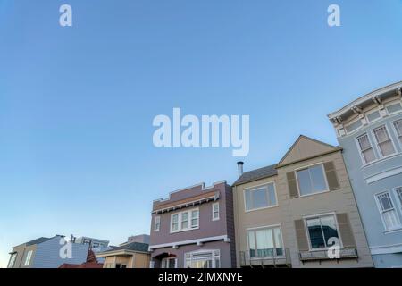 Schräg abgewinkelte Ansicht der Vorstadthäuser in San Francisco, Kalifornien. Reihe von Häusern mit bunten Wänden außen und verschiedenen architektonischen Struktur Stockfoto