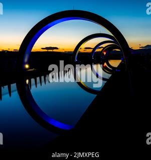 Blick auf das Falkirk Wheel bei Sonnenuntergang mit Lichtern in verschiedenen hellen Farben Stockfoto