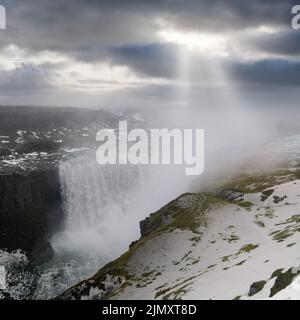 Malerisch voller Wasser großer Wasserfall Dettifoss Herbst langweiliger Blick auf den Tag mit Sonnenstrahlen durch Wolken, Nord Island. Stockfoto