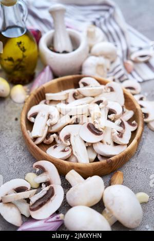 Champignon-Pilze in Holzschüssel in der heimischen Küche Stockfoto