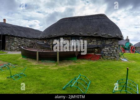 Das Skye Museum of Island Life in Kilmuir an der Küste der Isle of Skye mit strohgedeckten Hütten und Booten Stockfoto