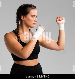 Seitenansicht fit Frau Kampfposition Stockfoto