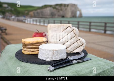 Vier berühmte Käse der Normandie, quadratische pont l'eveque, rund Camembert Kuhkäse, gelbe livarot, herzförmigen neufchatel und Blick auf die Promenade und ein Stockfoto