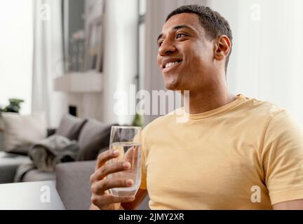 Portrait Mann zu Hause Glas trinken Wasser 2 Stockfoto