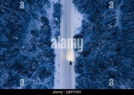 Luftaufnahme der verschneiten Straße mit Autos, Winterwald Stockfoto