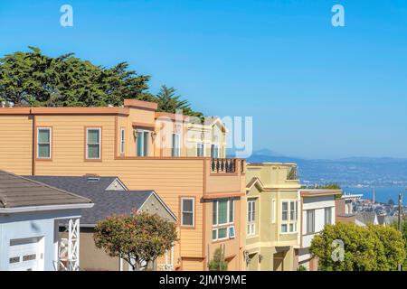 Dreistöckige Vorstadthäuser in einer Reihe mit Dachterrassen und Blick auf die Bucht in San Francisco, CA. Wohngebiet auf einem höheren Gebiet mit einer Reihe von Single Stockfoto