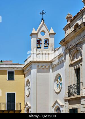 Kirchturm mit zwei Glocken in Mahón, Menorca, Spanien, mit mediterraner Architektur, weißer Fassade und blauem Sommerhimmel. Stockfoto