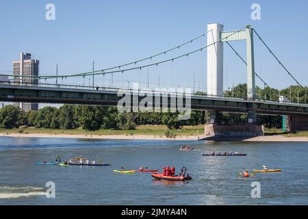 Die Mülheimer Brücke über den Rhein, Ruderer und Kajakfahrer, Köln, Deutschland. Die Mülheimer Brücke über den Rhein, Ruderer und Kajakfahrer, Köln, Deu Stockfoto