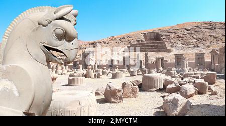 Steinskulptur von Greifen und Ruinen des Palastes von 100 Säulen und Grab von Artaxerxes III, am Hang des Rahmet Mount, Persepolis, Iran. UNES Stockfoto