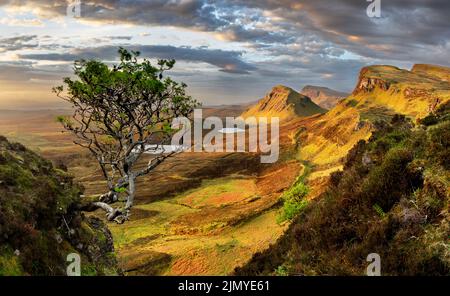 Schottland - wunderschöne Berglandschaft bei Sonnenaufgang über dem Quiraing und seiner steilen, kurvenreichen Bergstraße auf der Isle of Skye, Großbritannien Stockfoto