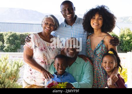 Porträt einer glücklichen, multirassischen Familie mit mehreren Generationen, die gemeinsam ihre Freizeit im Hof genießt Stockfoto