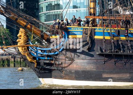 Tower Bridge, London, Großbritannien. 8. August 2022. Göteborg von Schweden ist eine Segelnachbildung der schwedischen Ost-Indiaman Göteborg I, die 1738 ins Leben gerufen wurde und London besucht, um Besucher an Bord zu begrüßen. Das hölzerne Nachbau-Schiff wurde 2003 gestartet und besuchte zuletzt 2007 London. Sie hat am Morgen die Themse hinaufgefahren, um unter der geöffneten Tower Bridge hindurch zu fahren, bevor sie dann wieder unter der Themse Quay in Canary Wharf abbiegt, wo sie für Besucher geöffnet sein wird. Bow, mit Galionsfigur, Namen und Crew-Mitgliedern Stockfoto