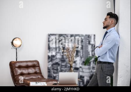 Mann, der mit gefalteten Händen seitlich zur Kamera steht Stockfoto