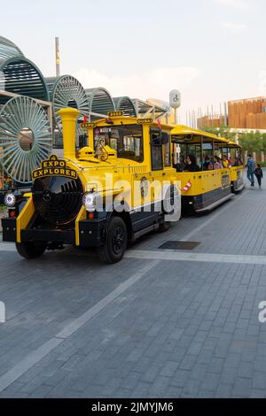 VAE, Dubai - 30. November 2021: EXPO 2020. Bunt gelbe Dampflokomotive transportiert Menschen auf der Ausstellung zwischen Pavillons. Stockfoto