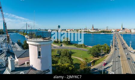 Eine Brücke über den Fluss Daugava in Riga mit einem vorbeifahrenden Zug. Stockfoto