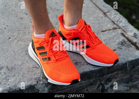 Tjumen, Russland-03. Mai 2022: Adidas Laufschuhe orange Farbe. Adidas, multinationales Unternehmen. Produktfotos. Selektiver Fokus Stockfoto
