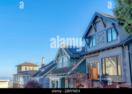 Außenansicht von Häusern in den Vororten von San Francisco, Kalifornien. Es gibt ein graues Haus auf der linken Seite mit Holztür und Ziegel am Eingang neben t Stockfoto