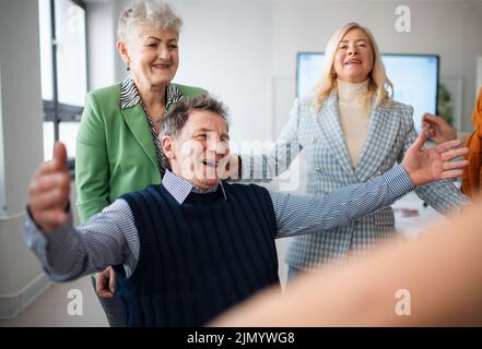 Glückliche Schüler treffen sich und umarmen sich im Klassenzimmer. Stockfoto