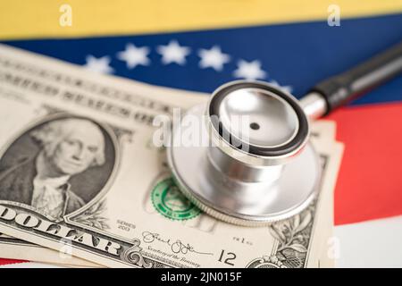 Schwarzes Stethoskop mit US-Dollar-Banknoten auf Hintergrund der venezolanischen Flagge, Geschäfts- und Finanzkonzept. Stockfoto