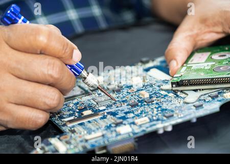 Techniker repariert die Leiterplatteninnenseite mit einem Lötkolben. Integrated Circuit. Das Konzept von Daten, Hardware, Techniker und Technolo Stockfoto