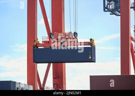 Terminal Kran bewegt einen Container in der Industriefracht por Hamburgt, Konzept für Transport, Versand und Logistik, Coy Space, ausgewählter Fokus Stockfoto