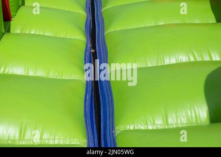 Grünes Trampolin. Aufblasbares Design. Details des Vergnügungsparks. Hindernisparcours. Stockfoto