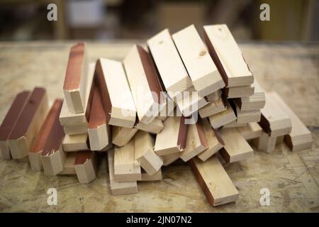 Rohlinge aus Holz. Vorstand in der Werkstatt. Details der Möbelproduktion. Tischlerei. Holzstangen. Stockfoto