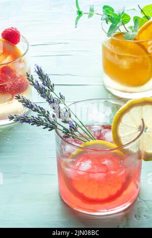 Sommercocktails oder Mocktails, kalte Getränke mit Früchten und Lavendelblüten, Party-Limonade Stockfoto