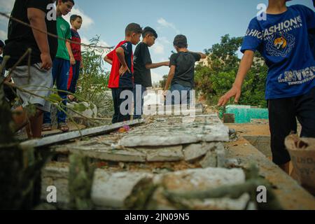Palästinenser inspizieren einen Friedhof, der durch israelische Luftangriffe beschädigt wurde, bei denen fünf Kinder im Flüchtlingslager Jabalia im nördlichen Gazastreifen getötet wurden, 8. August 2022 Foto von Habboub Ramez/ABACAPRESS.COM Stockfoto