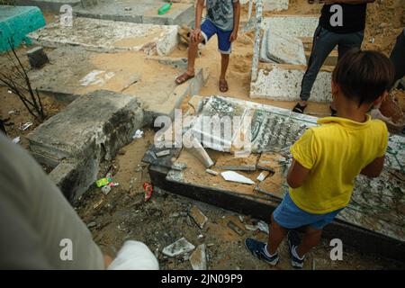 Palästinenser inspizieren einen Friedhof, der durch israelische Luftangriffe beschädigt wurde, bei denen fünf Kinder im Flüchtlingslager Jabalia im nördlichen Gazastreifen getötet wurden, 8. August 2022 Foto von Habboub Ramez/ABACAPRESS.COM Stockfoto